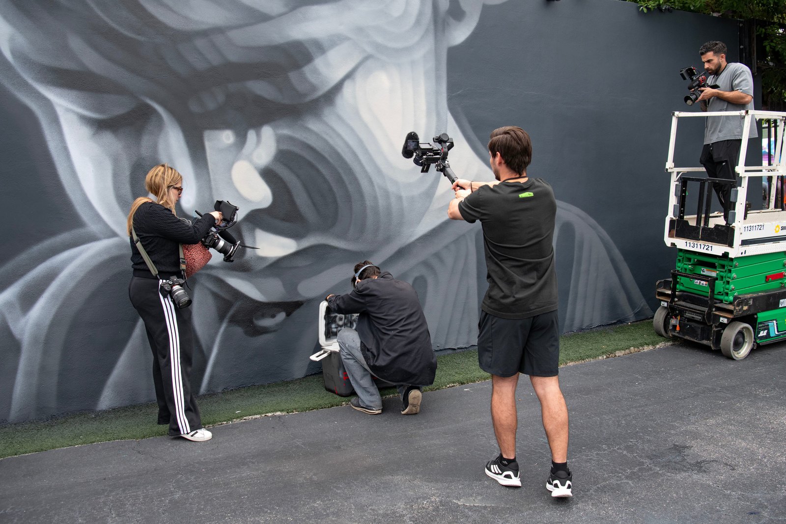 Four Zu Group crew members filming across a public art production