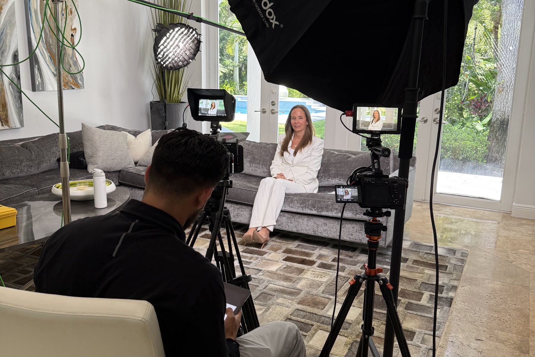 Zu directing a sit-down interview from behind a two-camera production setup